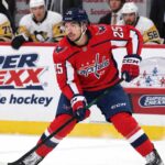 Jordan Kyrou Fantasy Hockey Projection: Can the Capitals Push Him Back to 70 Points? Jordan Kyrou in a Washington Capitals home jersey skates with the puck in front of a stylish Super Chexx bubble hockey boards ad and Pittsburgh Penguins bench