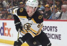 Mason Lohrei Trade Rumors: Why the Boston Bruins Could Listen Before Training Camp Boston Bruins defenseman skating with the puck during NHL game action as Boston Bruins trade rumors heat up before training camp