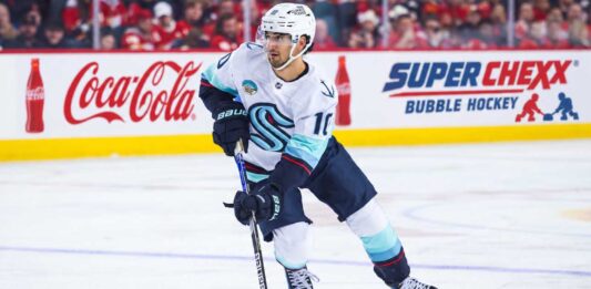 Matty Beniers Seattle Kraken 2026-27 fantasy hockey projection with Coca-Cola and Super Chexx Bubble Hockey rink board ads