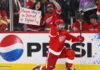 NHL News and NHL Rumors Today: Trade Buzz, Injuries and NHL Scores – September 26, 2026 Detroit Red Wings captain Dylan Larkin celebrates on one knee in front of cheering fans, including a female fan holding a “Please stay in Detroit Dylan!” sign, with a Pepsi board ad in the background.