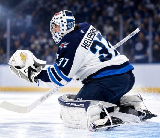 NHL News Today: Hellebuyck Trade Market Heats Up as Maple Leafs Add Brisson Connor Hellebuyck in Winnipeg Jets gear making a save during a game as NHL trade rumors and today’s NHL News spotlight his future