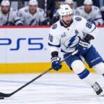 Nikita Kucherov Rumors: Why Has Tampa Bay Still Not Signed Its Superstar? Tampa Bay Lightning star forward skating with the puck in a game action shot with PS5 and McDonald’s ads on the boards in the background