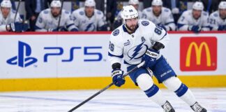 Nikita Kucherov Rumors: Why Has Tampa Bay Still Not Signed Its Superstar? Tampa Bay Lightning star forward skating with the puck in a game action shot with PS5 and McDonald’s ads on the boards in the background