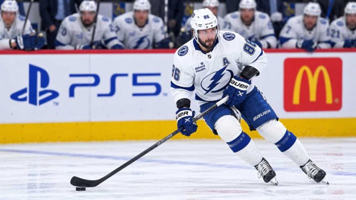 Tampa Bay Lightning star forward skating with the puck in a game action shot with PS5 and McDonald’s ads on the boards in the background