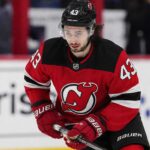 Quinn Hughes Trade Rumors: Could Contract Uncertainty Finally Give the Devils Their Opening? Quinn Hughes wearing a New Jersey Devils home jersey amid NHL trade rumors involving the Minnesota Wild and New Jersey Devils.