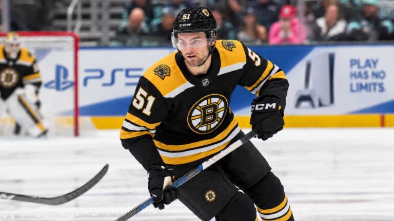 Shane Wright wearing a Boston Bruins home jersey amid NHL trade rumors involving the Seattle Kraken