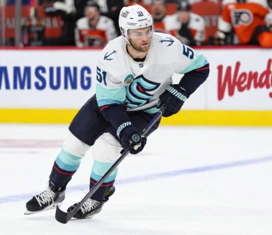 Seattle Kraken forward controls the puck during NHL action as Shane Wright trade rumors continue to generate buzz around Seattle