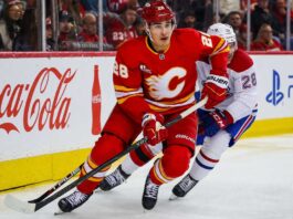 Zach Whitecloud Trade Rumors: Are the Canadiens Quietly Circling Calgary’s Most Valuable Trade Chip? Zach Whitecloud of the Calgary Flames battles a Montreal Canadiens player as trade rumors link Whitecloud to Montreal.
