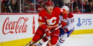 Zach Whitecloud Trade Rumors: Are the Canadiens Quietly Circling Calgary’s Most Valuable Trade Chip? Zach Whitecloud of the Calgary Flames battles a Montreal Canadiens player as trade rumors link Whitecloud to Montreal.