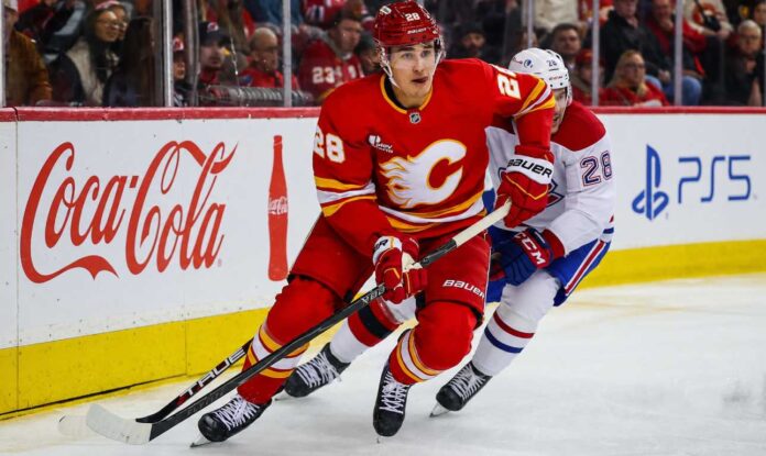 Zach Whitecloud of the Calgary Flames battles a Montreal Canadiens player as trade rumors link Whitecloud to Montreal.