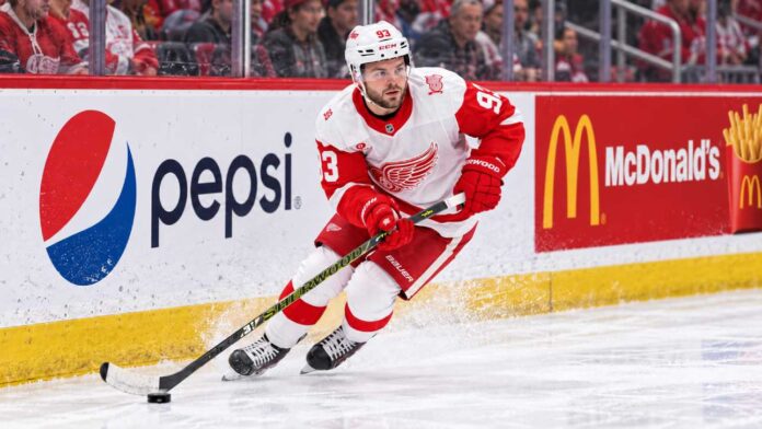 alex-debrincat-detroit-red-wings-trade-rumors-2026 Alex DeBrincat skating for the Detroit Red Wings as NHL trade rumors grow around his contract future in Detroit.