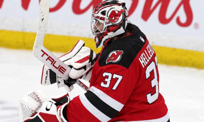 Connor Hellebuyck wearing a New Jersey Devils home jersey, red and black goalie equipment and Devils-themed mask in an edited image illustrating his blockbuster trade from the Winnipeg Jets in October 2026.