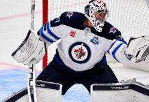 Connor Hellebuyck Trade Rumors: Is Utah About to Beat Buffalo to Winnipeg’s Star Goalie? Connor Hellebuyck of the Winnipeg Jets in his white away jersey making a save as NHL trade rumors link the star goaltender to the Buffalo Sabres and Utah Mammoth ahead of the October 23 decision.