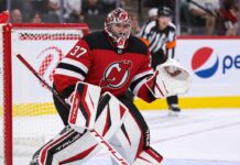 Connor Hellebuyck Traded to New Jersey Devils: Full Trade Package and NHL News Connor Hellebuyck wearing a New Jersey Devils home jersey and red, black and white goalie equipment following his blockbuster NHL trade from the Winnipeg Jets on October 23, 2026.