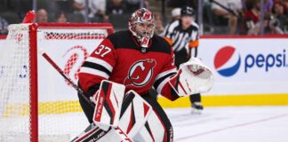 Connor Hellebuyck wearing a New Jersey Devils home jersey and red, black and white goalie equipment following his blockbuster NHL trade from the Winnipeg Jets on October 23, 2026.