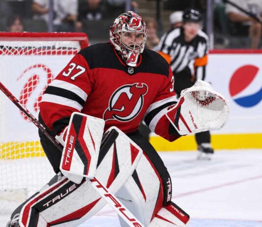 Connor Hellebuyck wearing a New Jersey Devils home jersey and red, black and white goalie equipment following his blockbuster NHL trade from the Winnipeg Jets on October 23, 2026.