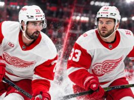 Dylan Larkin and Alex DeBrincat in Detroit Red Wings jerseys as DeBrincat's $91 million contract extension raises questions about Larkin's future amid NHL trade rumors.