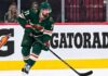 Dylan Larkin Trade Rumors: Did Detroit’s Latest Scouting Trip Reveal Its Next Move? Dylan Larkin wearing a Minnesota Wild home jersey in a trade rumor concept image as the Detroit Red Wings reportedly scout Minnesota ahead of a potential NHL blockbuster.