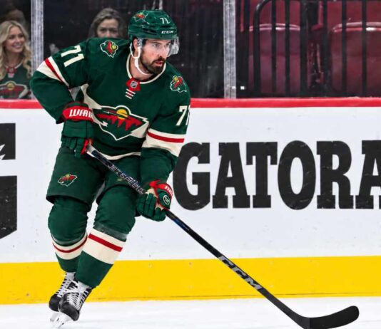 Dylan Larkin wearing a Minnesota Wild home jersey in a trade rumor concept image as the Detroit Red Wings reportedly scout Minnesota ahead of a potential NHL blockbuster.