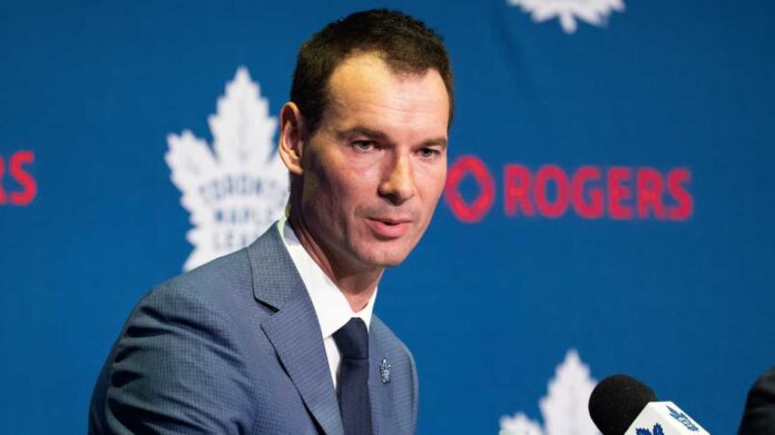 john-chayka-maple-leafs-defence-trade-news-2026 Toronto Maple Leafs general manager John Chayka speaking at a team press conference as Toronto evaluates defensive improvements and potential NHL trades.