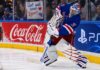 NHL News Today: Shesterkin Out for Season, Canadiens Trade Struble, Edvinsson Rumors Heat Up New York Rangers goalie Igor Shesterkin in action as a female Rangers fan holds a "Get well soon Igor!" sign behind the glass, following his season-ending injury. Coca-Cola and PS5 advertisements line the boards.