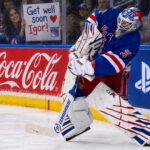 NHL News Today: Shesterkin Out for Season, Canadiens Trade Struble, Edvinsson Rumors Heat Up New York Rangers goalie Igor Shesterkin in action as a female Rangers fan holds a "Get well soon Igor!" sign behind the glass, following his season-ending injury. Coca-Cola and PS5 advertisements line the boards.