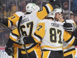 Pittsburgh Penguins forwards Rickard Rakell (67) and Sidney Crosby (87) celebrate with teammates during an NHL game amid Penguins trade rumors involving Kyle Dubas, Erik Karlsson, Kris Letang and Bryan Rust.