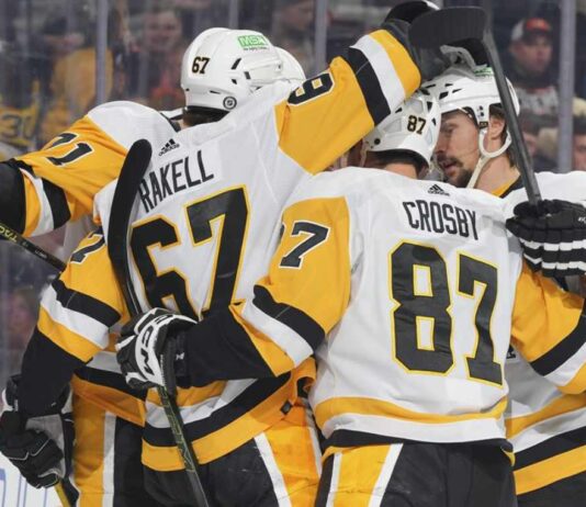 Pittsburgh Penguins forwards Rickard Rakell (67) and Sidney Crosby (87) celebrate with teammates during an NHL game amid Penguins trade rumors involving Kyle Dubas, Erik Karlsson, Kris Letang and Bryan Rust.