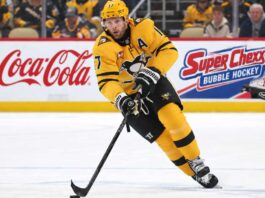 Bryan Rust of the Pittsburgh Penguins skates with the puck as NHL trade rumors intensify amid speculation that Kyle Dubas could move veteran players in a roster shakeup.