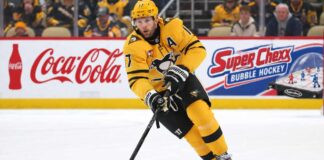 Bryan Rust of the Pittsburgh Penguins skates with the puck as NHL trade rumors intensify amid speculation that Kyle Dubas could move veteran players in a roster shakeup.