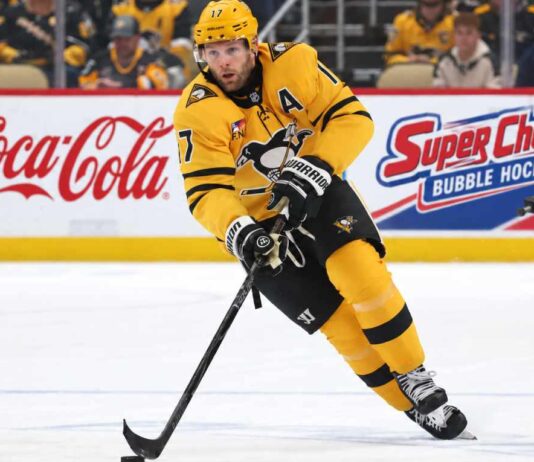 Bryan Rust of the Pittsburgh Penguins skates with the puck as NHL trade rumors intensify amid speculation that Kyle Dubas could move veteran players in a roster shakeup.