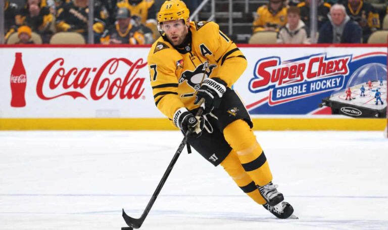 Bryan Rust of the Pittsburgh Penguins skates with the puck as NHL trade rumors intensify amid speculation that Kyle Dubas could move veteran players in a roster shakeup.