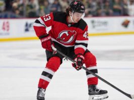 Quinn Hughes pictured in a New Jersey Devils home jersey as NHL trade rumors link the Minnesota Wild defenseman to New Jersey following the Connor Hellebuyck blockbuster trade.