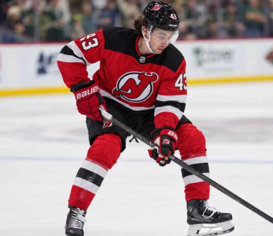 Quinn Hughes pictured in a New Jersey Devils home jersey as NHL trade rumors link the Minnesota Wild defenseman to New Jersey following the Connor Hellebuyck blockbuster trade.