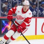 Simon Edvinsson skates for the Detroit Red Wings in front of Toronto Maple Leafs fans amid NHL trade rumors and contract uncertainty.