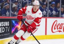 Simon Edvinsson Trade Rumors: Are Teams Testing the Detroit Red Wings? Simon Edvinsson skates for the Detroit Red Wings in front of Toronto Maple Leafs fans amid NHL trade rumors and contract uncertainty.