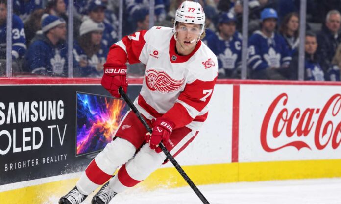 simon-edvinsson-detroit-red-wings-trade-rumors Simon Edvinsson skates for the Detroit Red Wings in front of Toronto Maple Leafs fans amid NHL trade rumors and contract uncertainty.