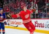 Simon Edvinsson of the Detroit Red Wings celebrates a goal beside New York Islanders defenseman Alexander Romanov as NHL trade rumors swirl around a potential $9 million Islanders offer sheet.